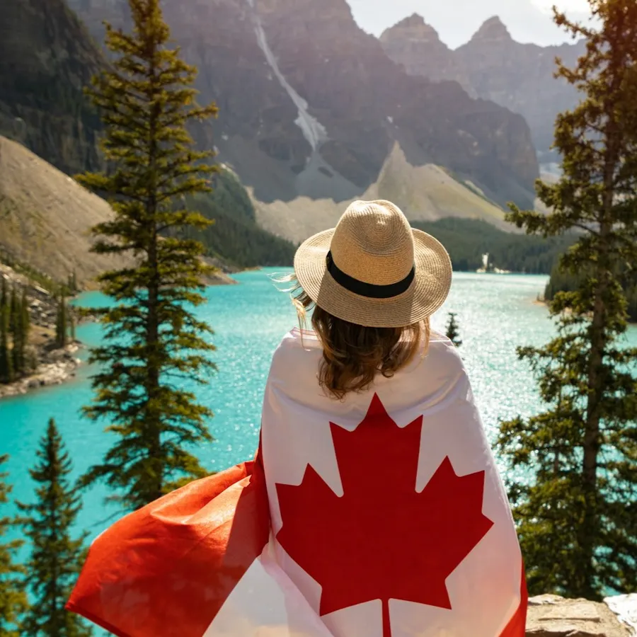 Una viatgera embolicada amb la bandera del Canadà davant de Moraine Lake